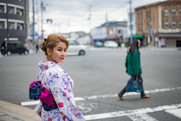 Frau in traditioneller japanischer Tracht zu Fuß unter Tori-Tore am Fushimiinari-Schrein Kyoto Japan