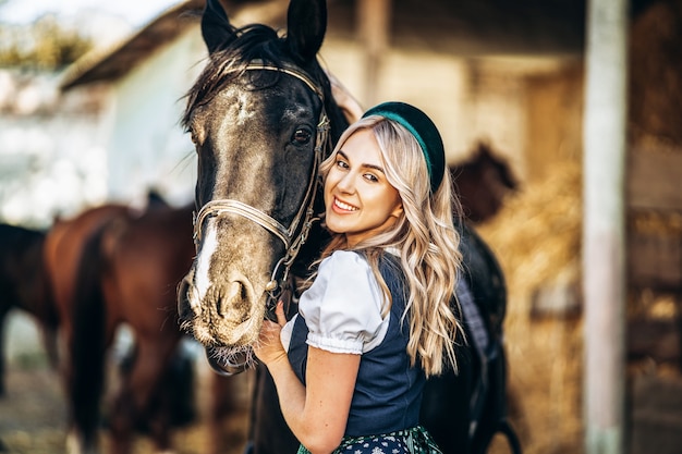 Frau in traditioneller Kleidung mit einem Pferd