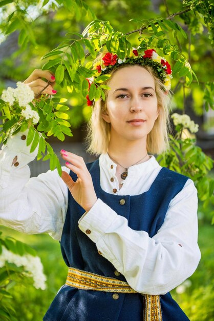 Frau in traditioneller Kleidung posiert auf der Natur im Dorf