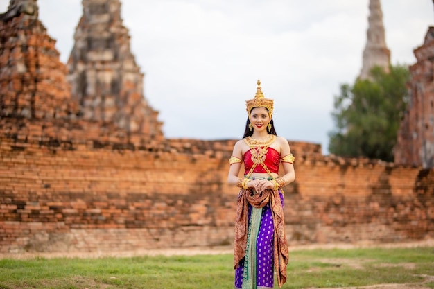 Frau in traditioneller Kleidung steht vor dem Tempel