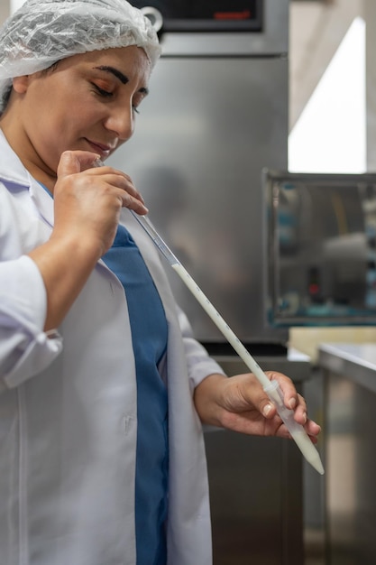 Frau in Uniform analysiert Milchprodukte in einem Labor