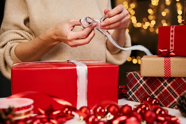 Frau in warmer Pulloververpackung Geschenkbox mit Kraftpapier Geschenk für Winterferien Weihnachten und