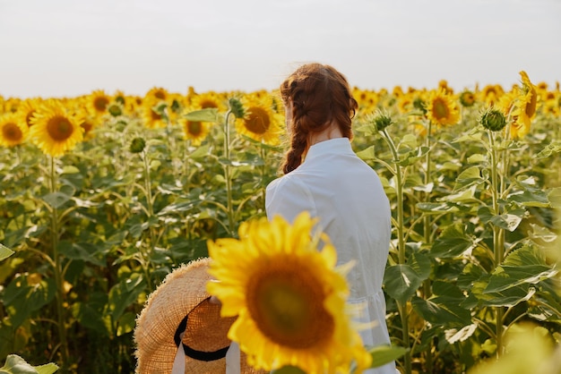 Frau in weißem Kleid mit Schwanz in einem Sonnenblumenfeld Natur Landschaft Hochwertiges Foto