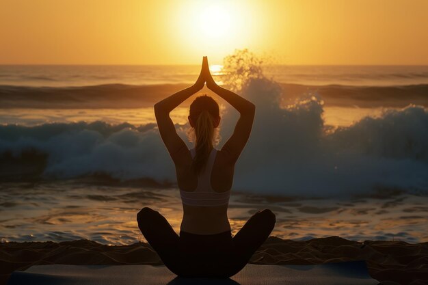 Frau in Yoga-Pose auf einer Matte bei Sonnenaufgang, Wellen im Hintergrund