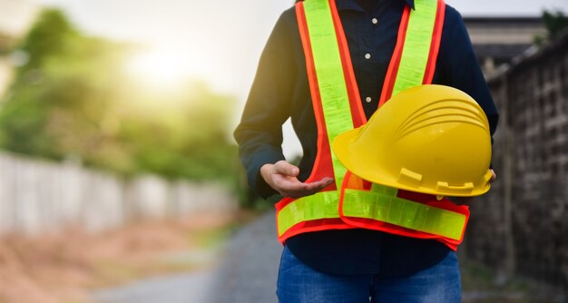 Frau Ingenieur mit Helm vor Baustellenbau