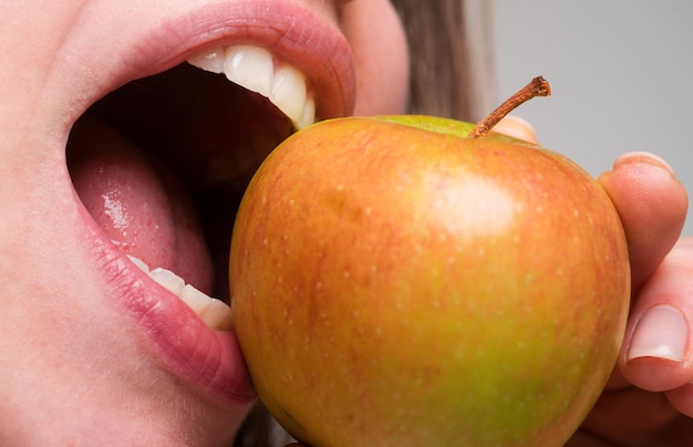 Frau isst Apfel gesunde Ernährung und gesunde Zähne Beißen eines Apfels Mund aus nächster Nähe