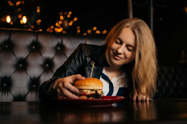 Frau isst Burger im Café