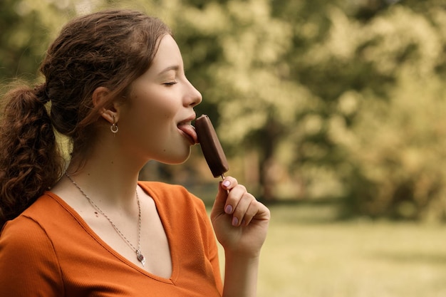 Frau isst Eis im Park