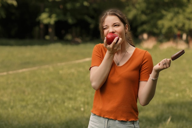 Frau isst Eis und Apfel