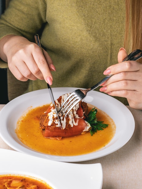 Frau isst ihr Mittagessen im Restaurant Kohlrouladen und geröstete Paprika