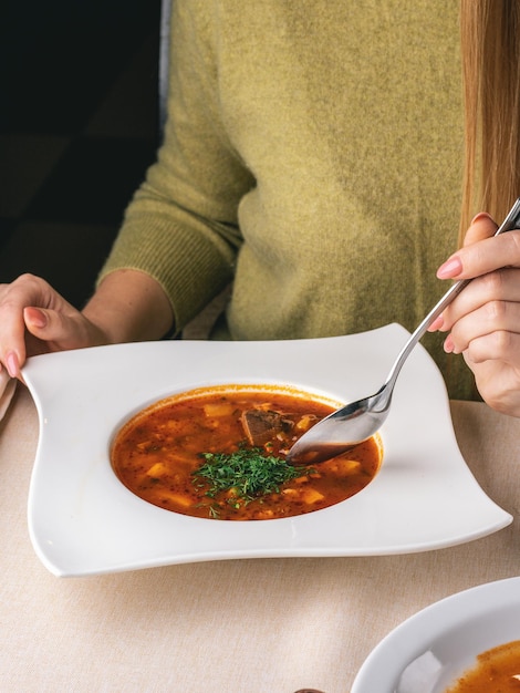 Frau isst ihr Mittagessen im Restaurant Suppe Borschtsch