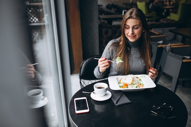 Foto frau isst salat in einem café