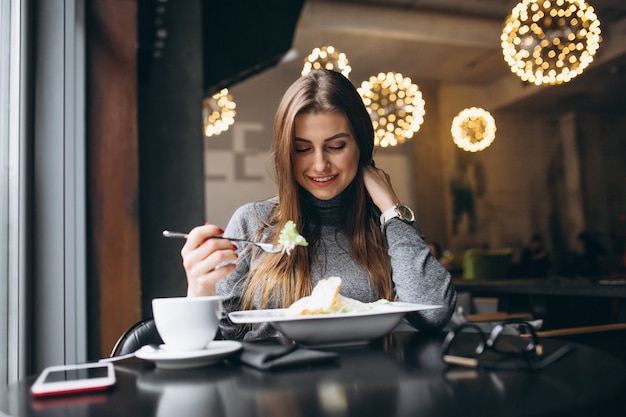 Frau isst Salat in einem Café