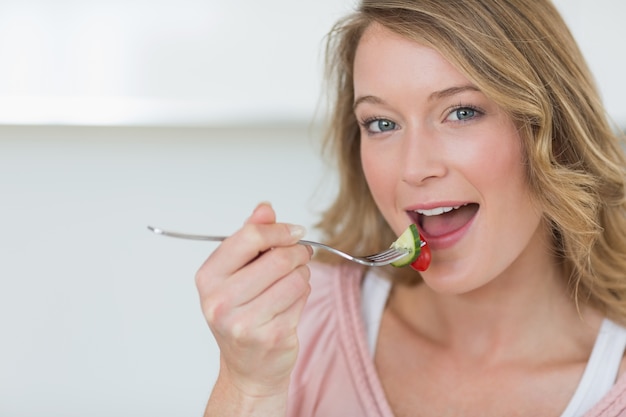 Frau isst Salat mit Gabel