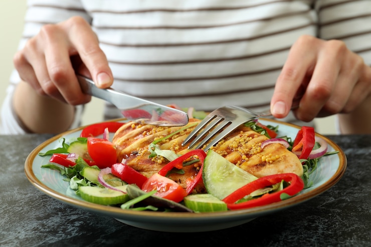 Foto frau isst salat mit gegrilltem hühnchen