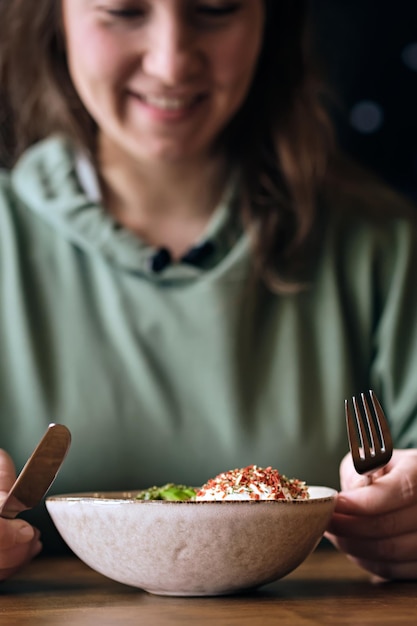 Frau isst vegetarischen Salat im Café Gesunde Schüssel mit pochiertem Buchweizenei und Avocadosauce Selektiver Fokus
