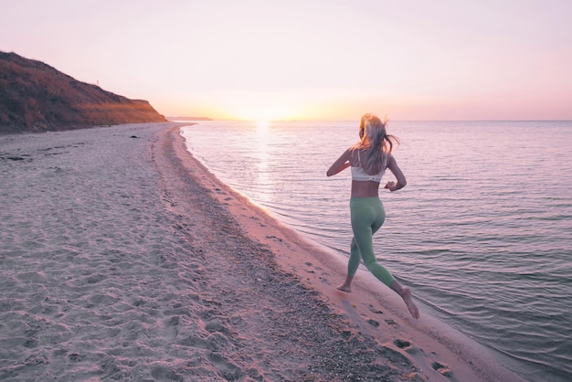 Frau ist mit Sportübungen am Strand beschäftigt