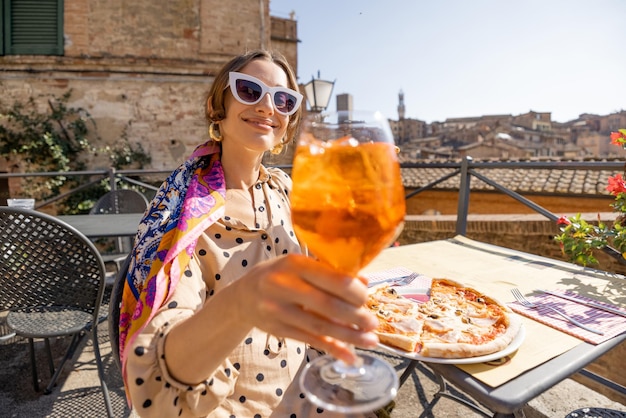 Frau jubelt mit einem Glas Wein in die Kamera, während sie nach Italien reist