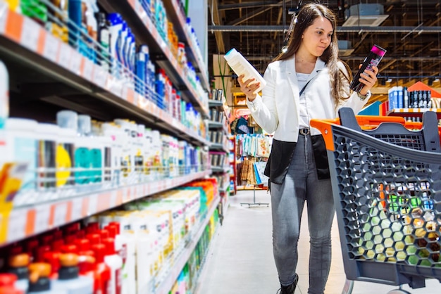 Frau kann sich nicht entscheiden, welches Shampoo sie kaufen soll