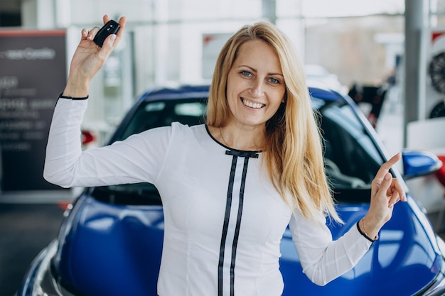 Frau kauft ein neues Auto in einem Autosalon