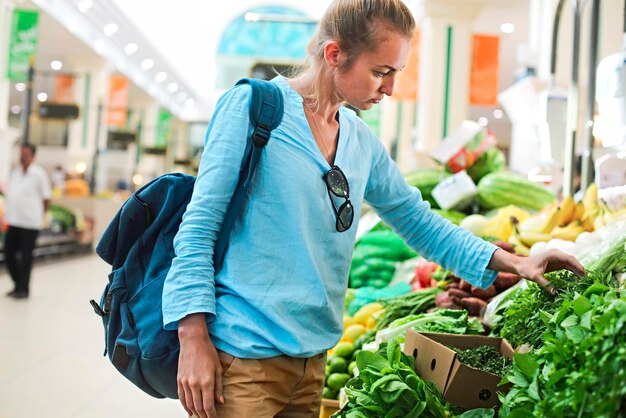 Foto frau kauft gemüse am marktstand