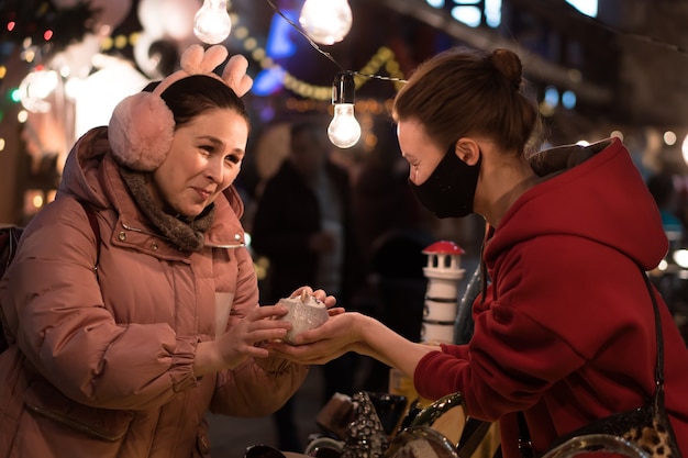 Frau kauft Geschenke im Weihnachtsmarkt