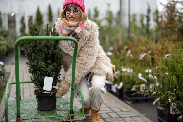 Frau kauft im Winter Pflanzen auf dem Markt unter freiem Himmel ein