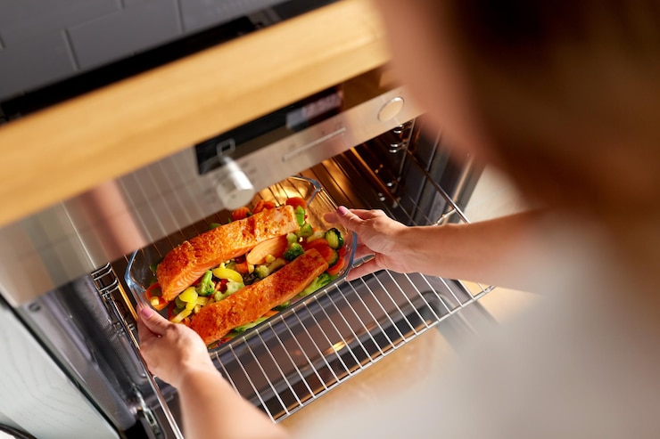 Foto frau kocht essen im ofen in der küche zu hause