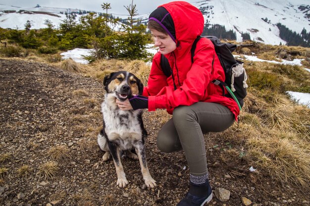 Foto frau kratzt hund bei hochland-landschaftsfotografie