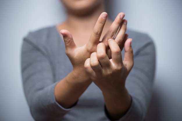 Frau kratzt sich an der Hand