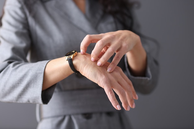 Frau kratzt sich mit den Nägeln an der Hand. Neurotische Manifestationen im Frauenkonzept