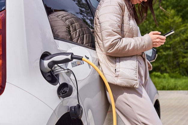 Frau lädt elektroauto auf