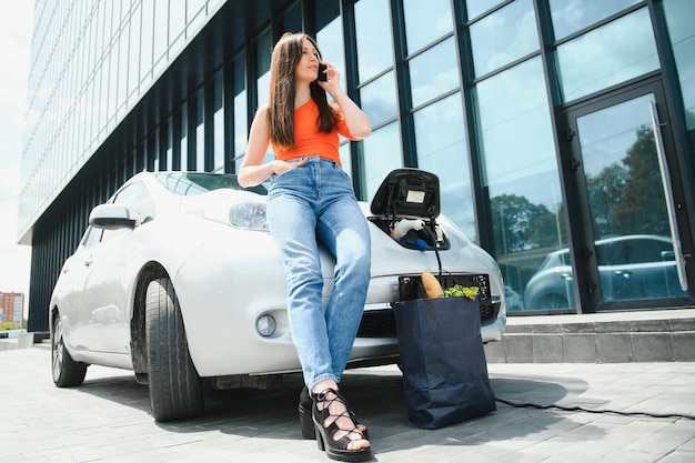 Frau lädt Elektroauto auf