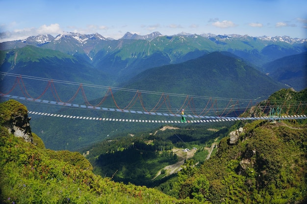 Frau läuft auf einer Seilhängebrücke im Kaukasus Russland herum. Hochwertiges Foto