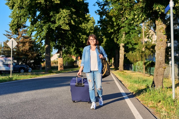 Frau läuft mit Koffer und Rucksack auf der Straße. Reisetourismus Reise Urlaub Weg Geschäftsreise Konzept