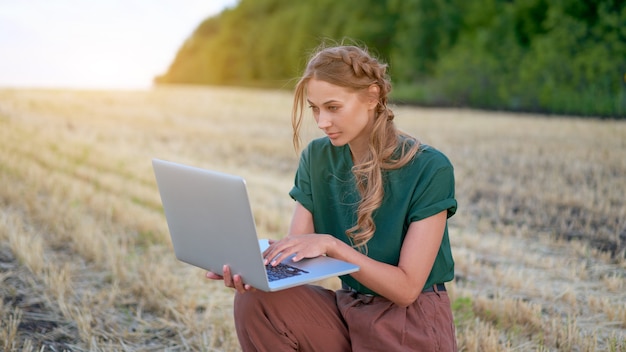 Frau Landwirt Smart Farming stehendes Ackerland lächelnd mit Laptop Weiblicher Agronom Spezialist Forschung Überwachung Analyse Daten Agribusiness