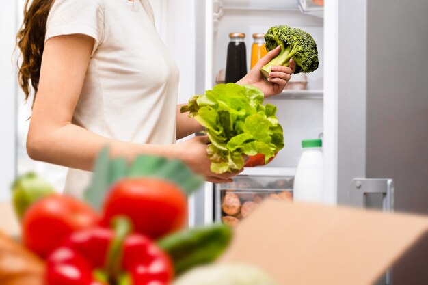 Frau legt Essen in den Kühlschrank