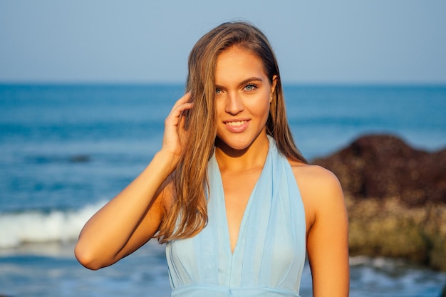 Frau legte SPF und Sonnencreme auf das Gesicht. Porträt des schönen Mädchens, Nahaufnahme eines schneeweißen Lächelns, blaue Augen und perfekt saubere Haut. weibliches Modell am Strand glückliche Sommerzeit am tropischen Paradies am Ufer