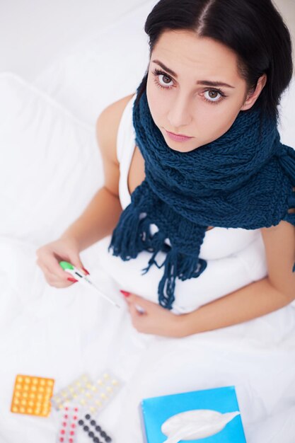 Frau leidet unter Kälte mit Gewebe im Bett liegend