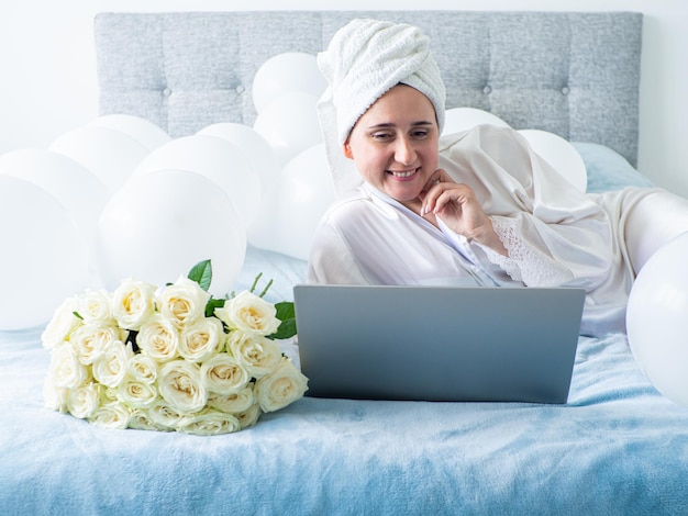 Frau liegt auf dem Bett mit Dekorationen mit Luftballons für die Geburtstagsfeier