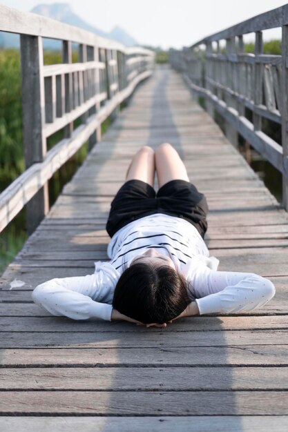 Frau liegt auf einer Fußgängerbrücke