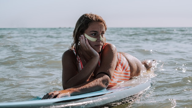 Frau liegt auf ihrem Surfbrett