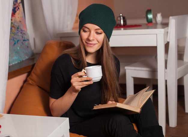 Frau liest Buch und trinkt Tee im Café