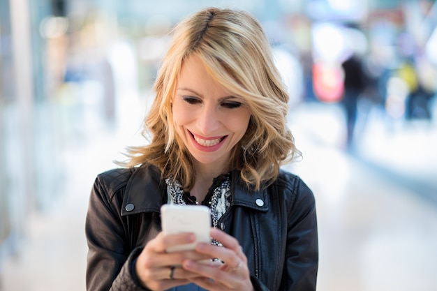 Foto frau liest eine nachricht an ihrem telefon