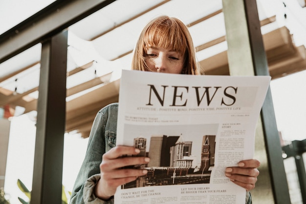 Frau liest eine Zeitung in einem Café