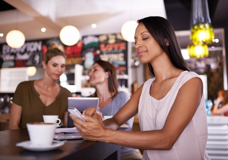 Foto frau liest und telefoniert in sozialen medien im café und kunde entspannt sich mit latte im restaurant glückliche person und scrollt mit dem smartphone online mit einem nachrichtenartikel oder bewertung des cafés auf der blog-website