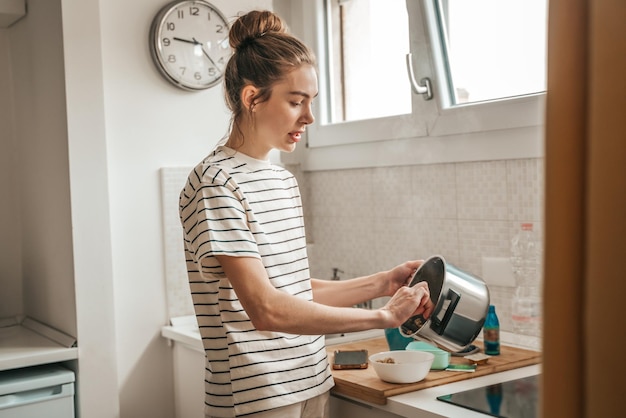 Frau löffelt sich eine Portion Haferbrei aus