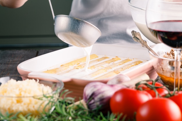 Foto frau machen cannelloni mit käse