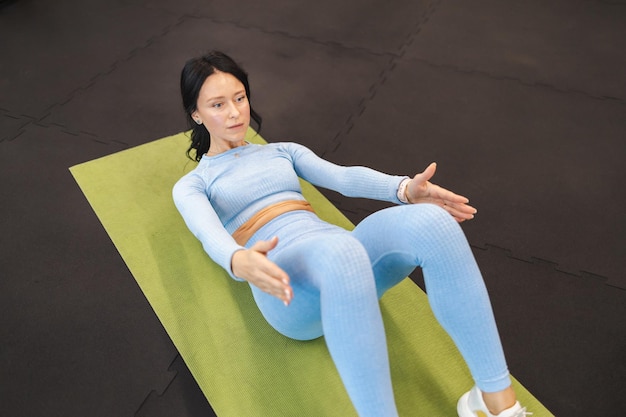 Frau macht Bauchmuskelübungen im Fitnessstudio