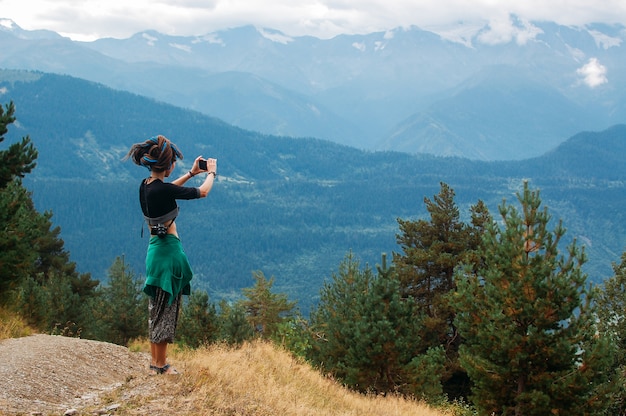 Frau macht ein Foto von Bergen